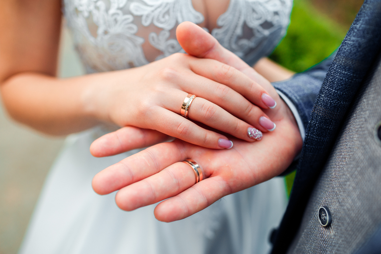 Wedding rings in the hands of the bride and groom.
